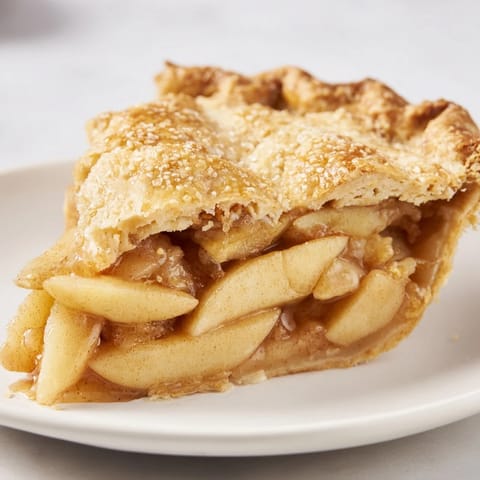 Warm apple pie with a scoop of vanilla ice cream, smelling of cinnamon and baked apples.