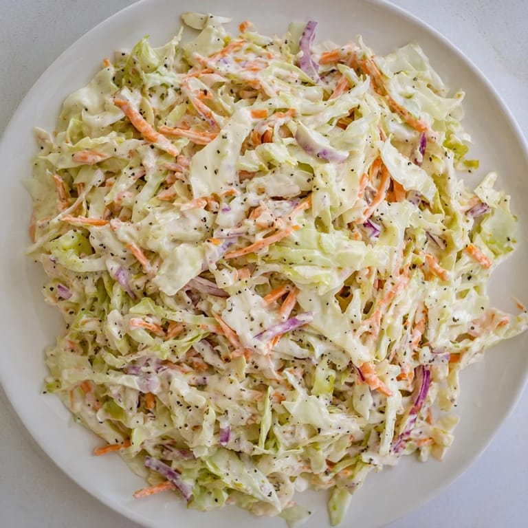 Freshly tossed coleslaw, showcasing vibrant shredded cabbage and carrots, ready to be served.