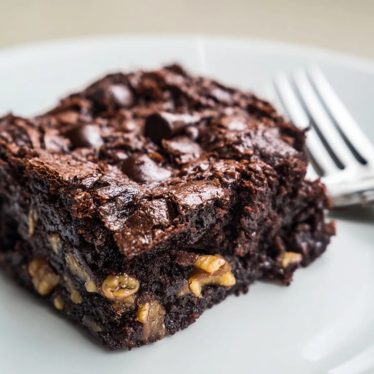 A plate of homemade brownies, intensely chocolate, with a perfectly textured, delicious bite.