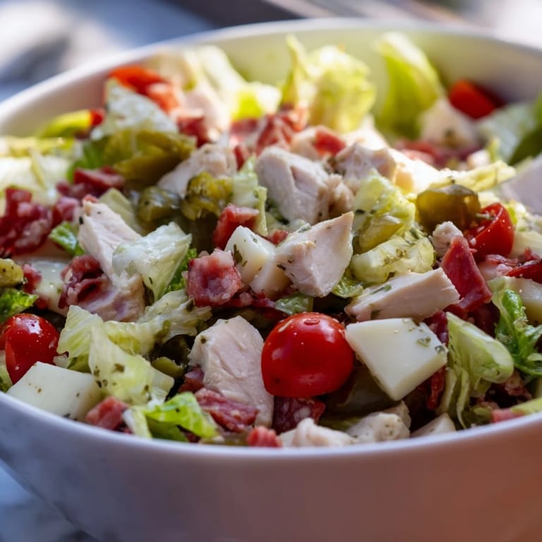 A hearty bowl of Italian Deli Chopped Chicken Salad, tossed with cherry tomatoes, red onion, cucumber, and a tangy herb vinaigrette.