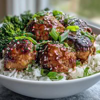 Savory Honey Garlic Turkey Meatball Bowls with fluffy rice and bright green broccoli, topped with sesame seeds and sliced green onions.