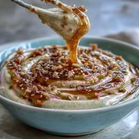 Creamy tahini dressing drizzled over a vibrant salad with fresh greens and roasted vegetables.  