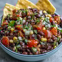 Three-Ingredient Cowboy Caviar Dip: a colorful mix of black beans, corn, and pico de gallo in a serving bowl.